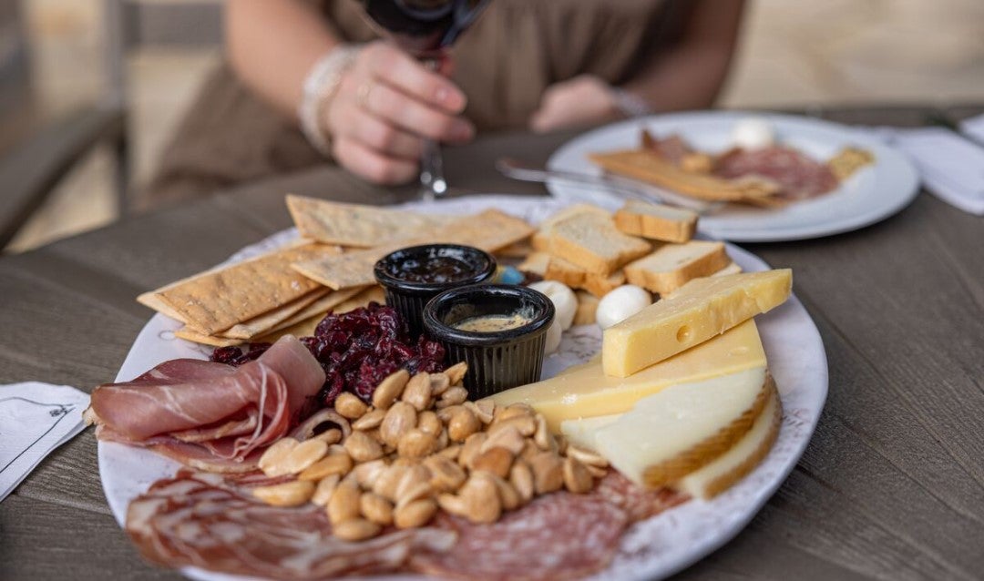 Charcuterie plate with meats, nuts, and cheeses.