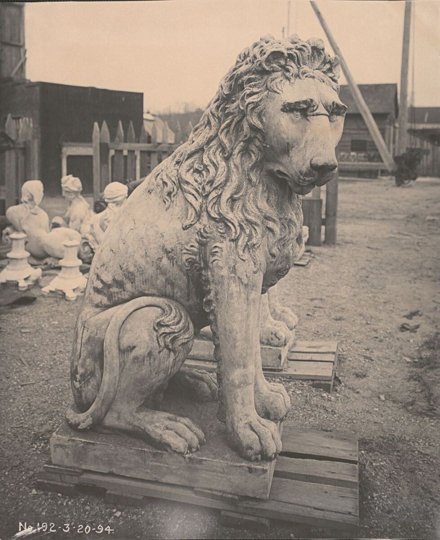 Archival image of a marble lion in front of Biltmore House