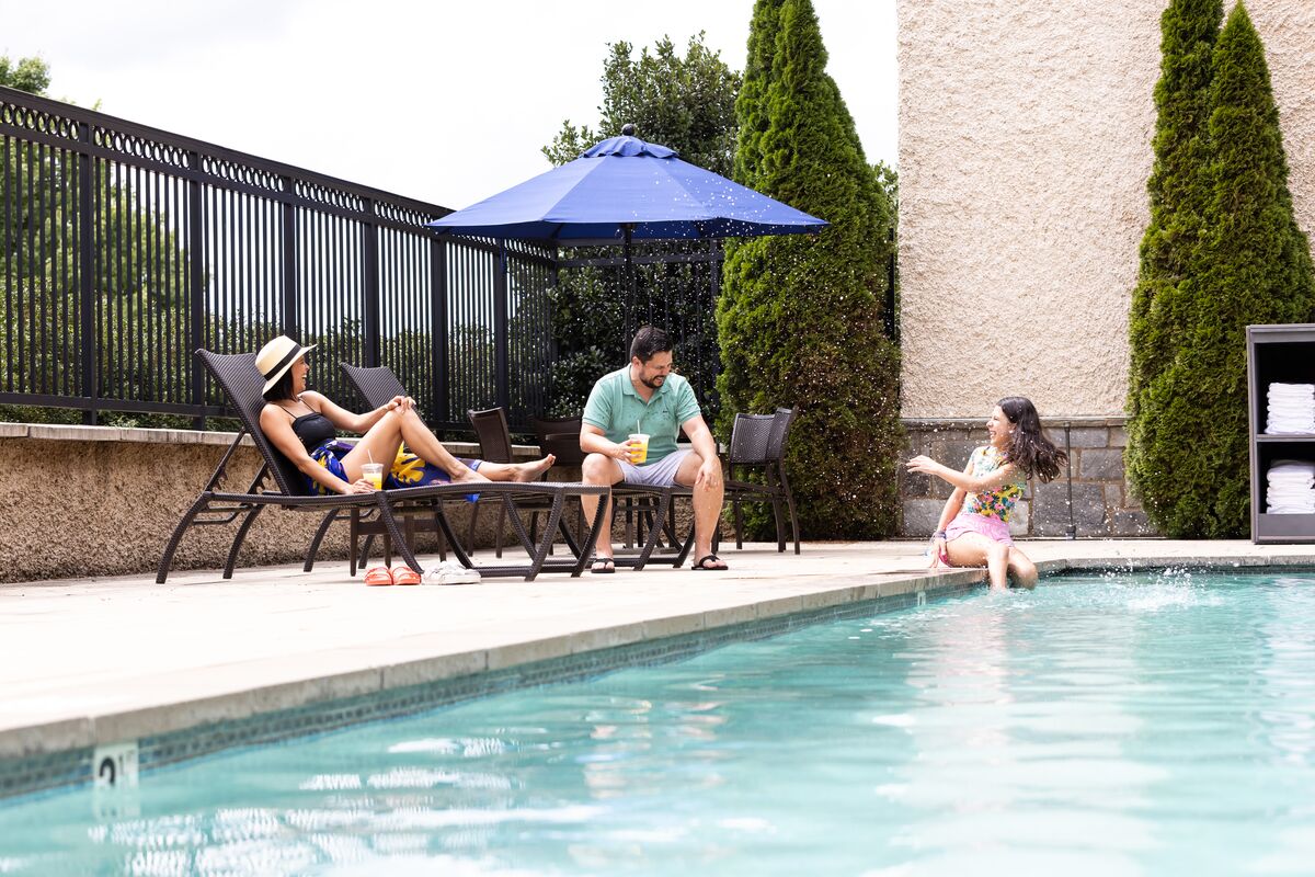 Family laughs poolside at Village Hotel
