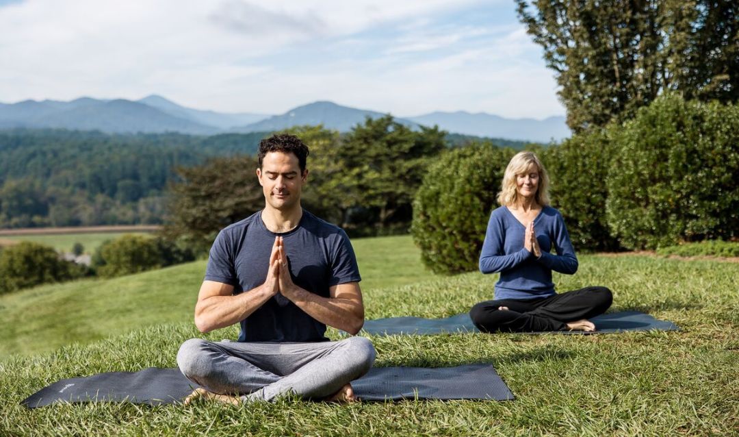 A man and women doing yoga at The Inn on Biltmore Estate.