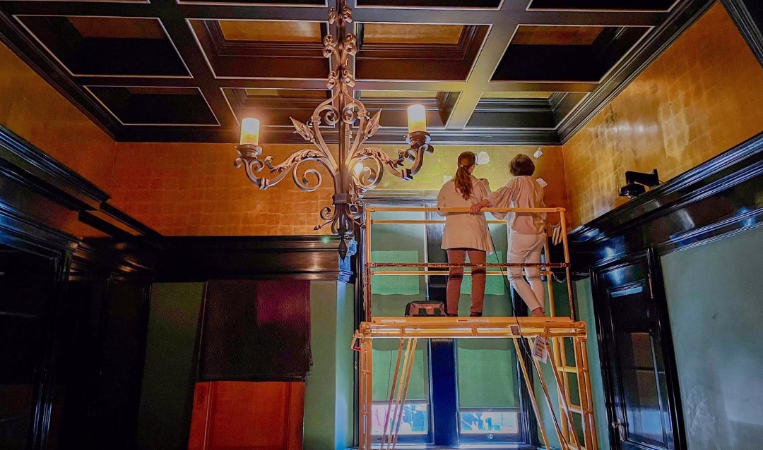 Two women on scaffolding in the Gun Room at Biltmore House.